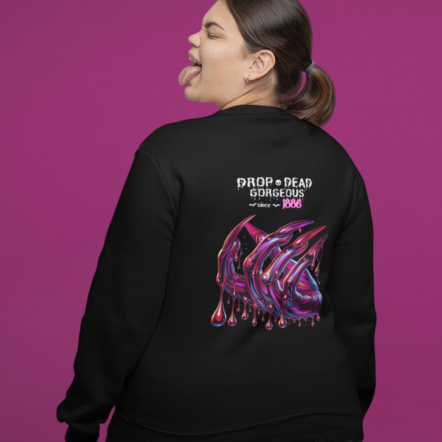 Drop-dead Gorgeous Sweatshirt in black, made from organic cotton. Female model showcasing the back view of the sweatshirt on a purple background.