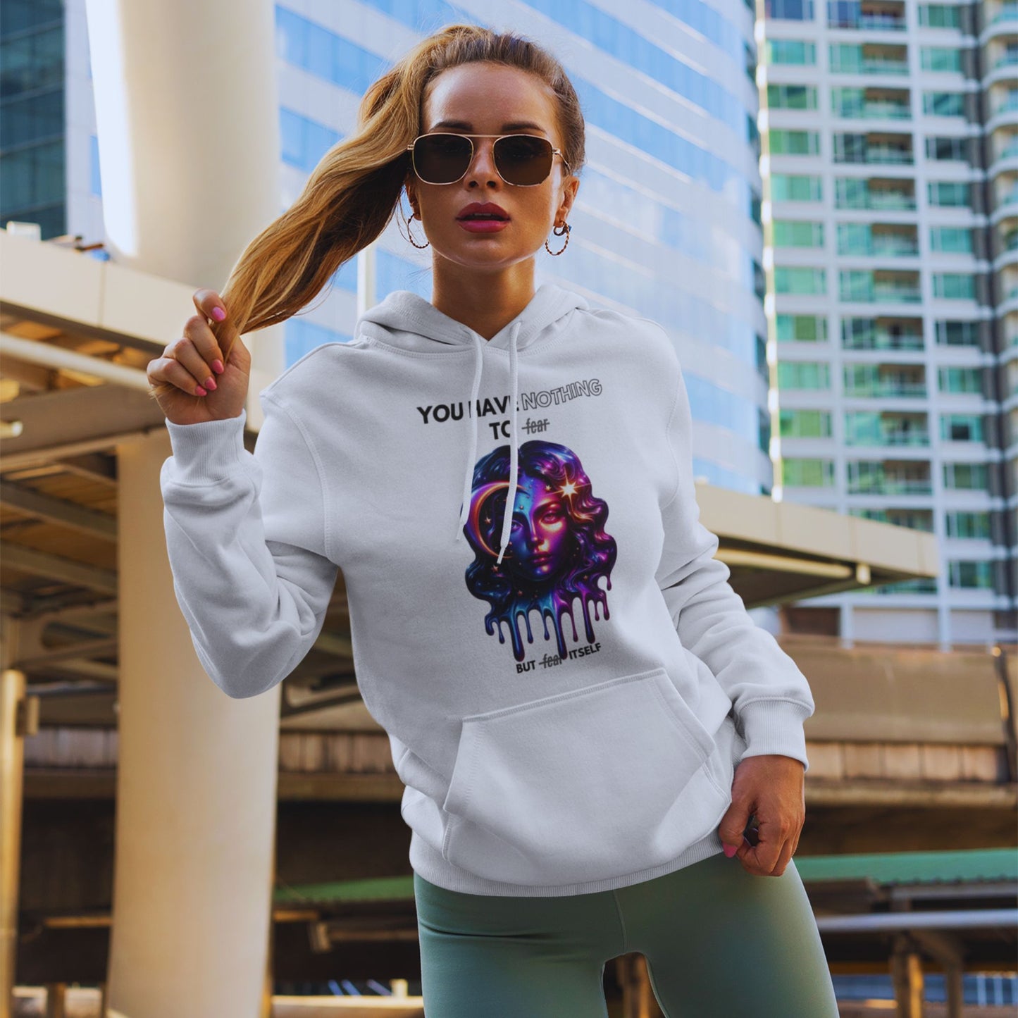Nothing to fear Hoodie hers in white, made from organic cotton. Model showcasing hoodie in lifestyle setting while pulling her hair.