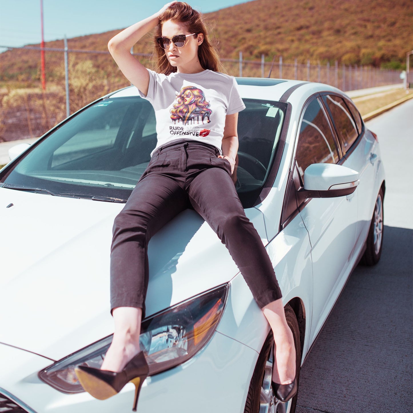 Rude and offensive Shirt in white, made from organic cotton. Model showcasing front while sitting on a car.