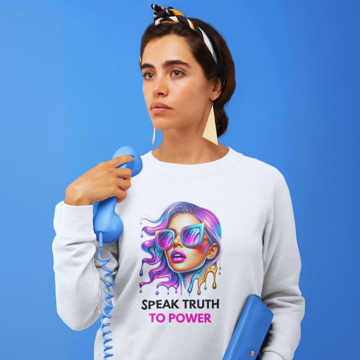 Speak Truth to Power hers Sweatshirt in white, made from organic cotton. Front view showing a model on a blue background holding a blue phone.