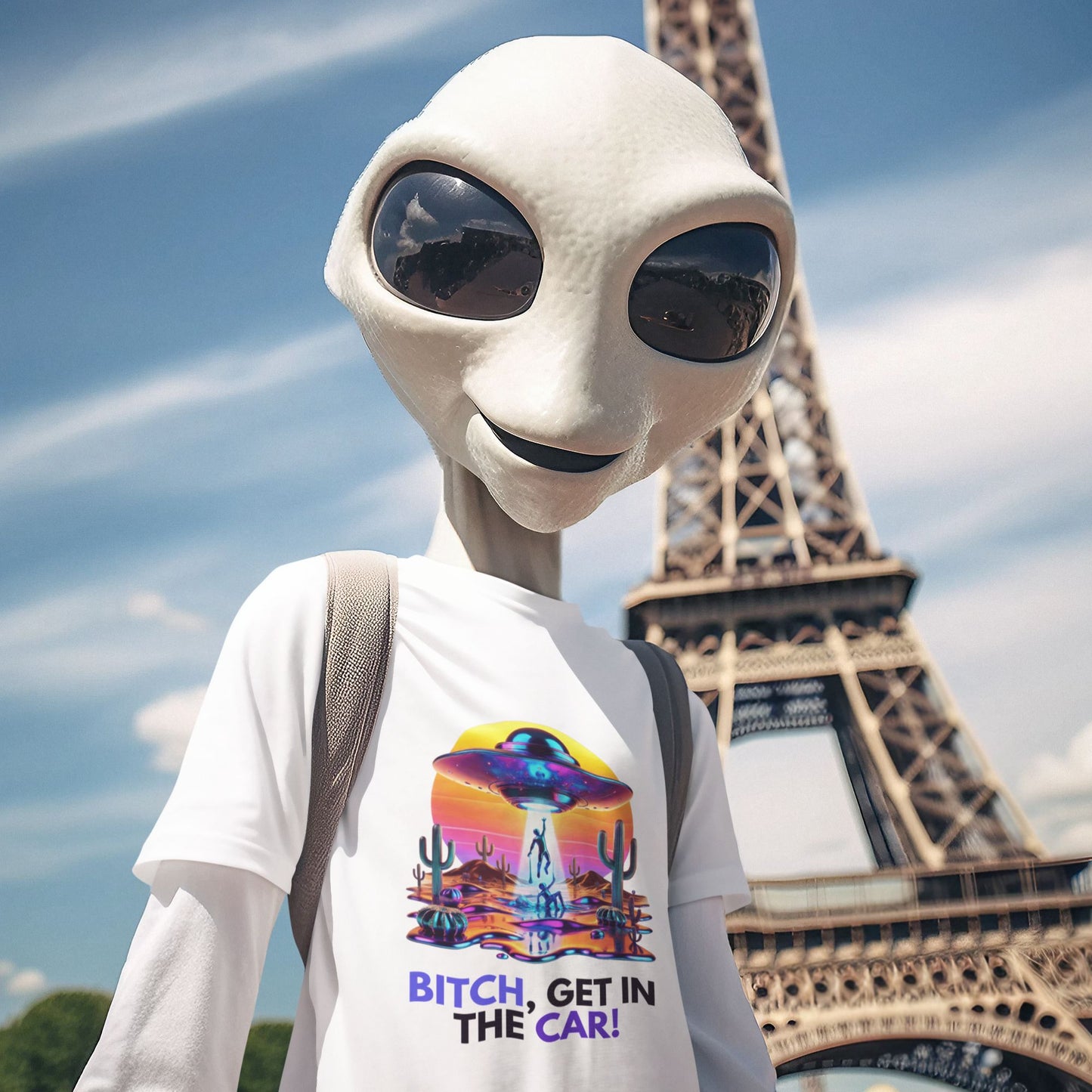 Bitch, get in the car Alien Abduction Shirt in white, made from organic cotton. Friendly alien modeling the shirt in front of the Eiffel Tower.