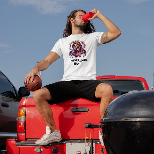 Man sitting on a red truck bed with a sports ball and drink, wearing a white t-shirt with text.