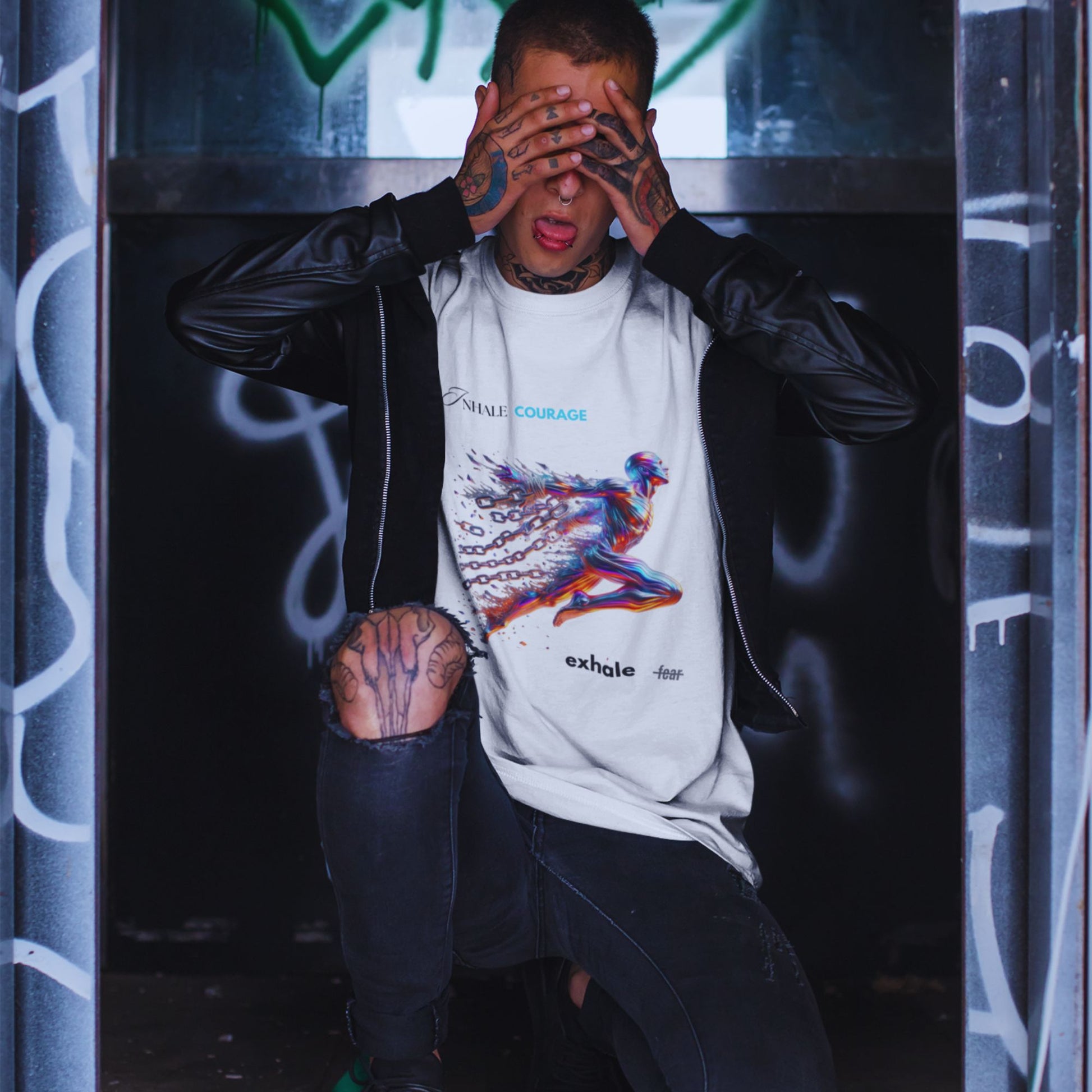 Inhale courage exhale fear Shirt in white, made from organic cotton in conversion. Tattooed male model showcasing the shirt paired with a vegan leather jacket.