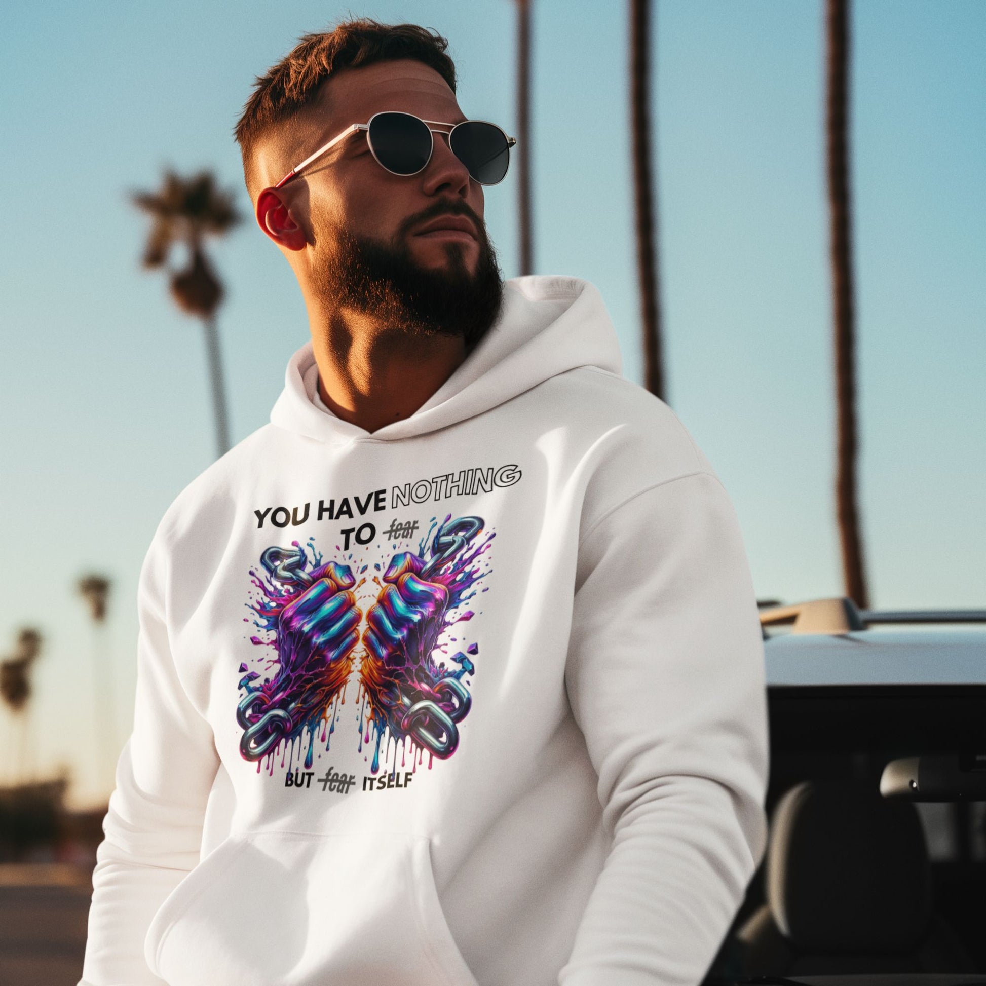 Nothing to fear Hoodie his in white, made from organic cotton. Male model in sunglasses showcasing the hoodie in a lifestyle setting.