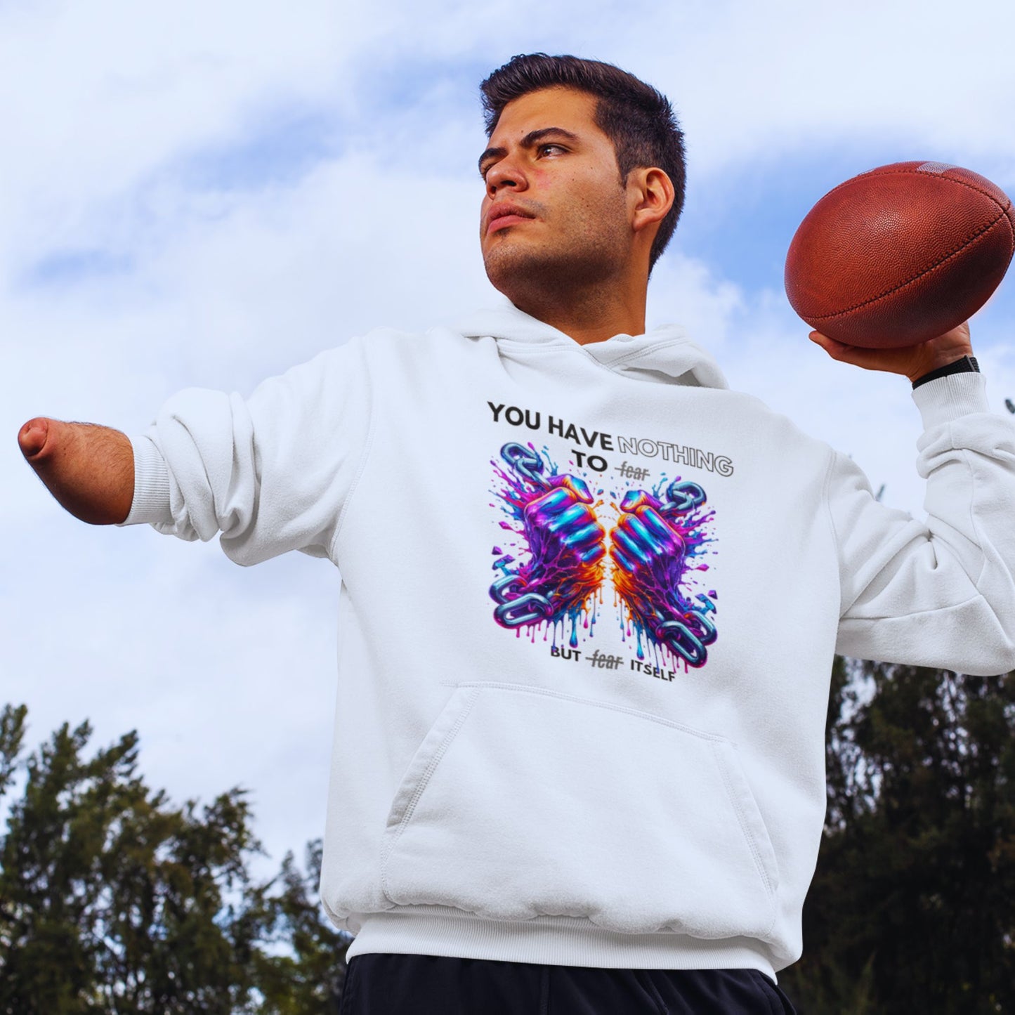Nothing to fear Hoodie his in white, made from organic cotton. Disabled male model showcasing the hoodie while playing football.