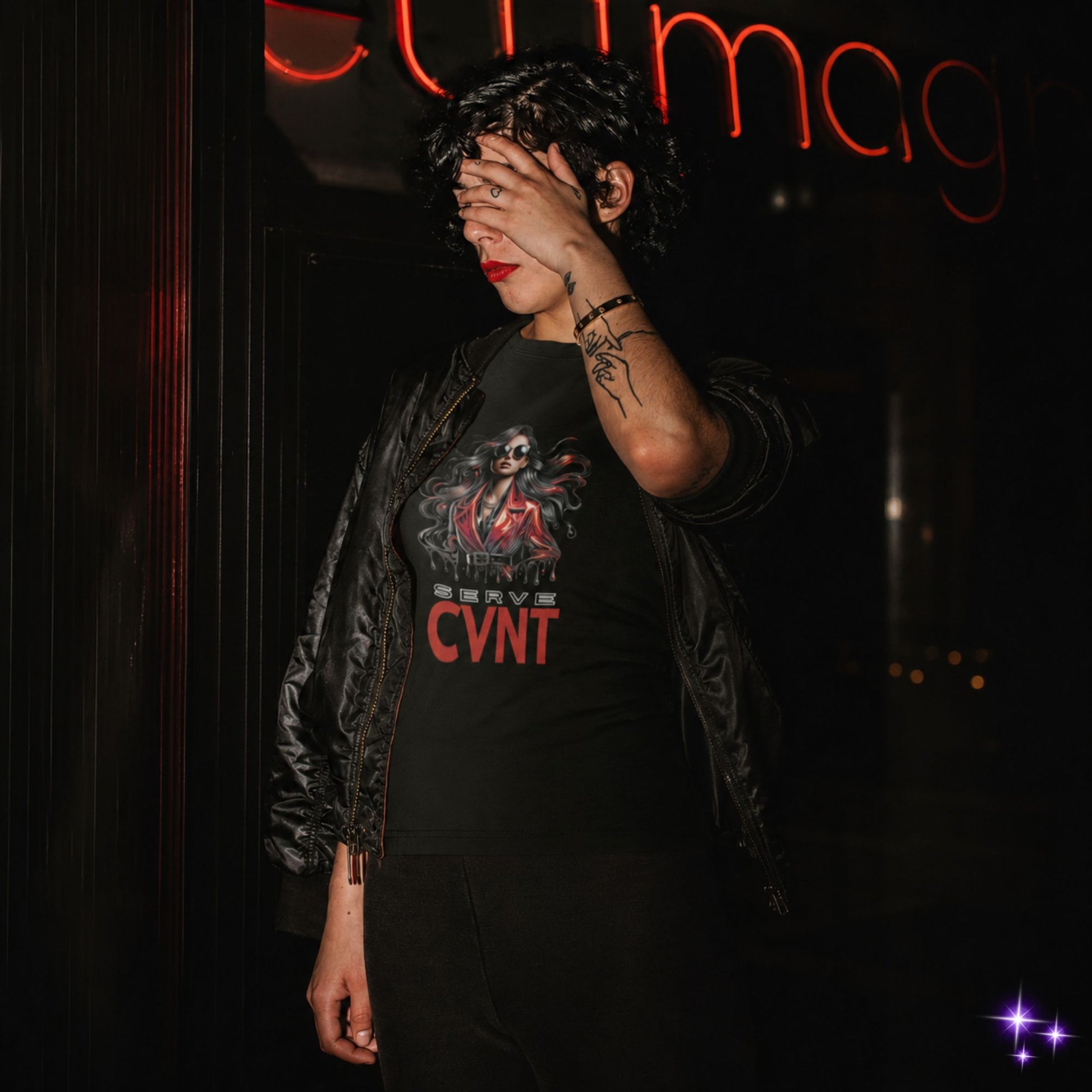 Person wearing a black t-shirt with red text and graphics, standing against a dark background.