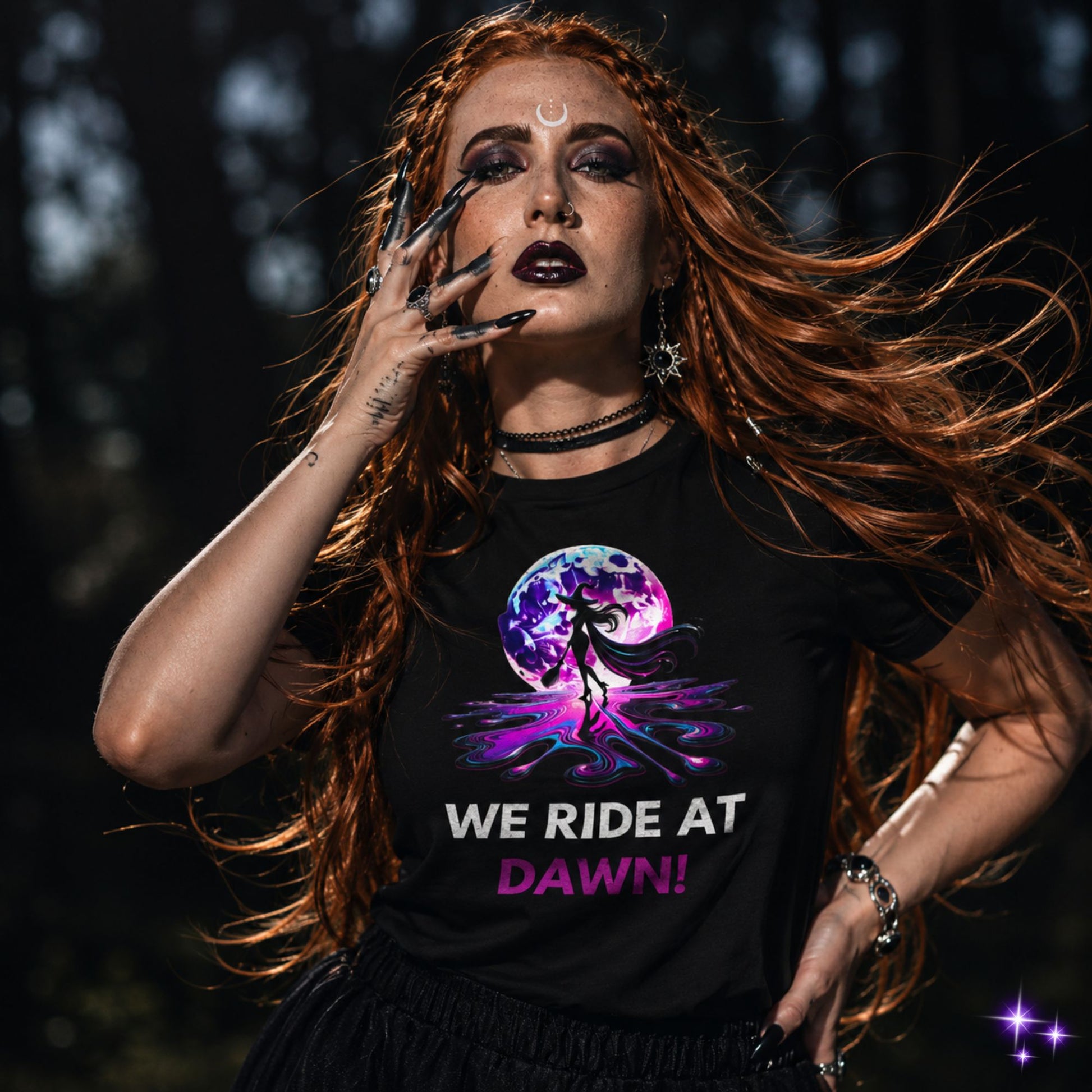 A person wearing a black t-shirt with a graphic design and text 'WE RIDE AT DAWN!' standing in a natural outdoor setting.