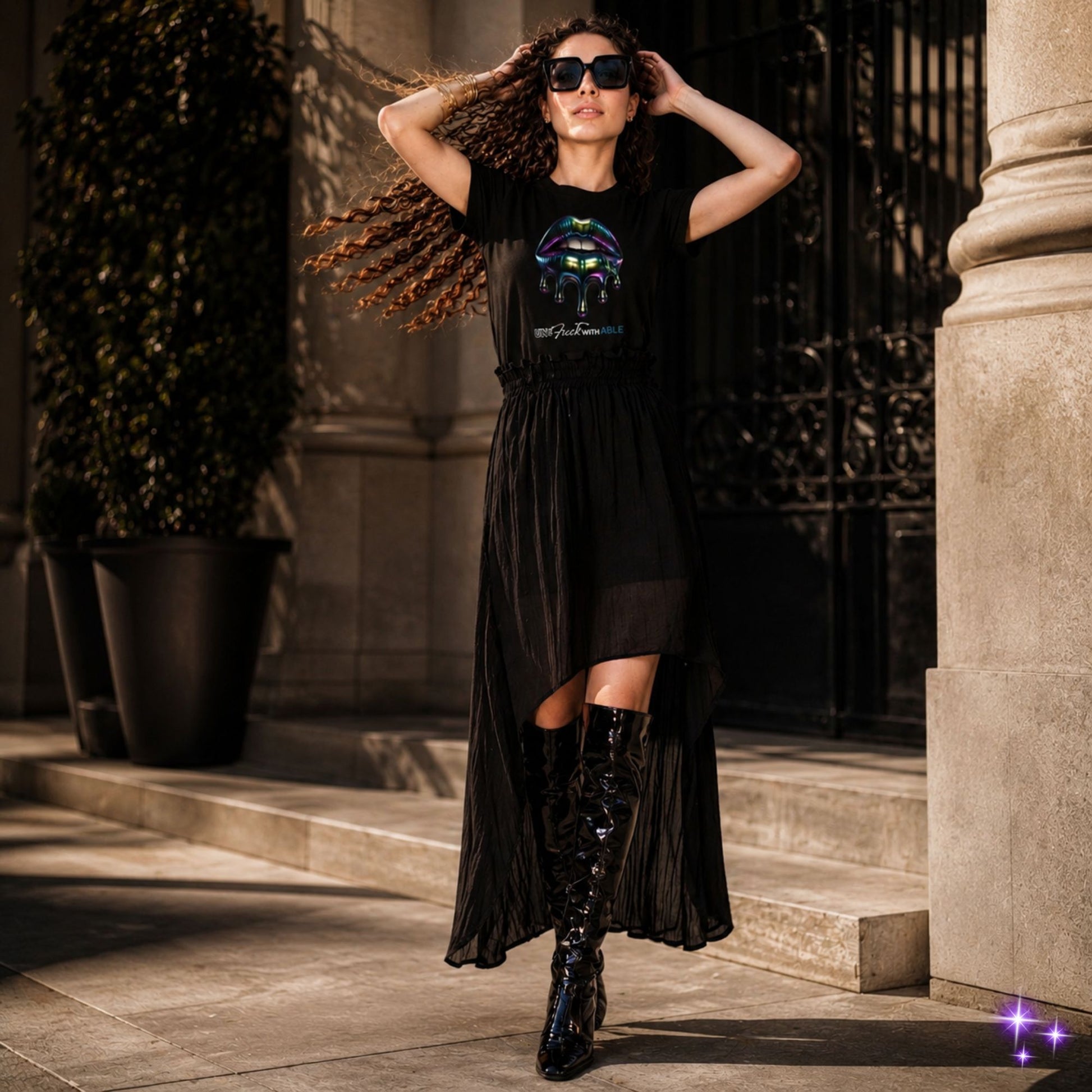 Woman wearing a black dress with a graphic design in front of an entrance.