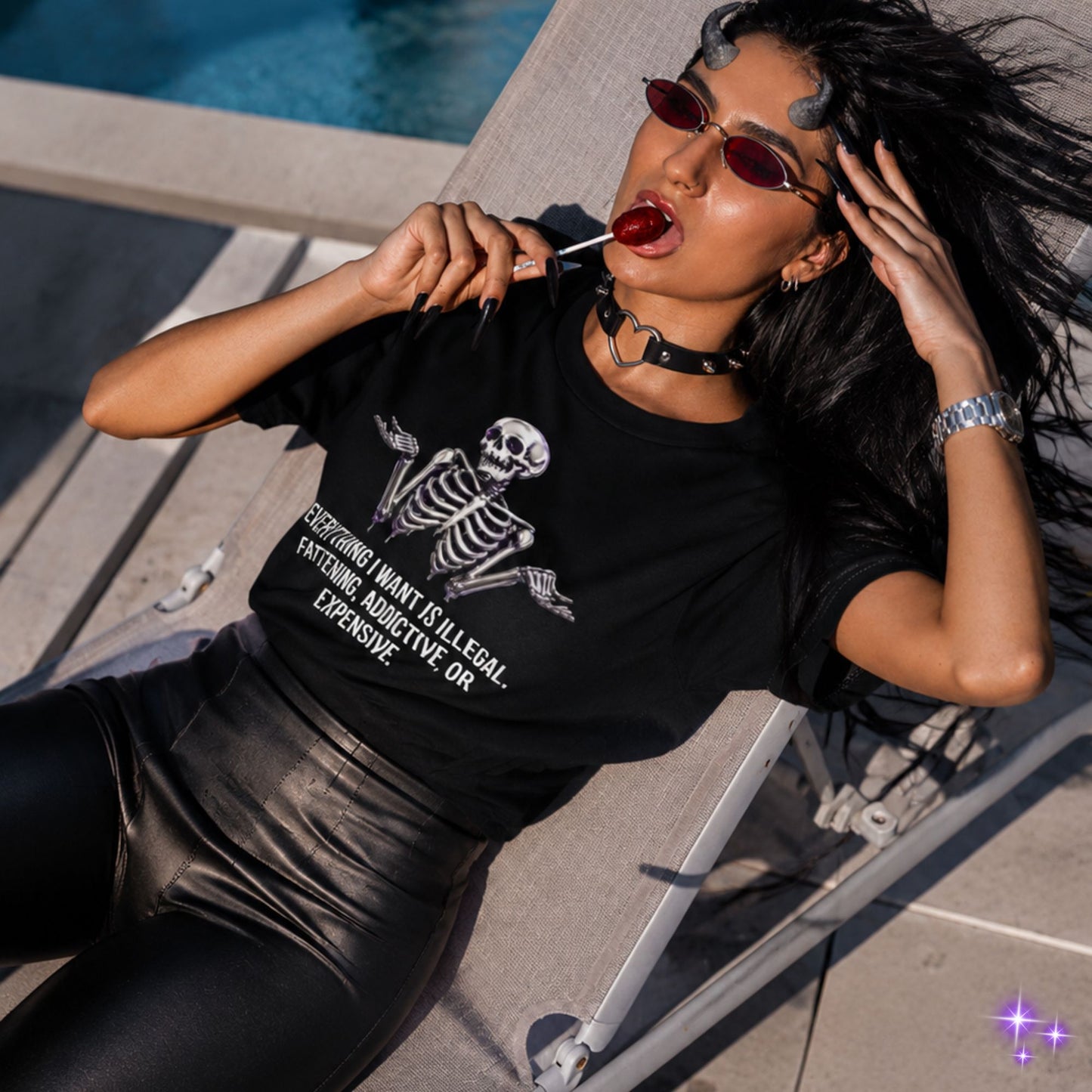 Woman wearing a black t-shirt with a skeleton design, sitting by a pool.