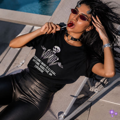 Woman wearing a black t-shirt with a skeleton design, sitting by a pool.