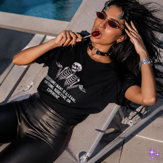 Woman wearing a black t-shirt with a skeleton design, sitting by a pool.