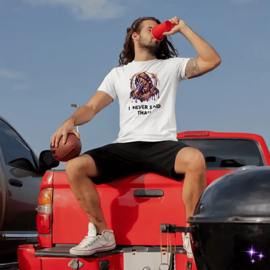 Man sitting on a red truck holding a football and drinking from a red cup, with a clear blue sky in the background.